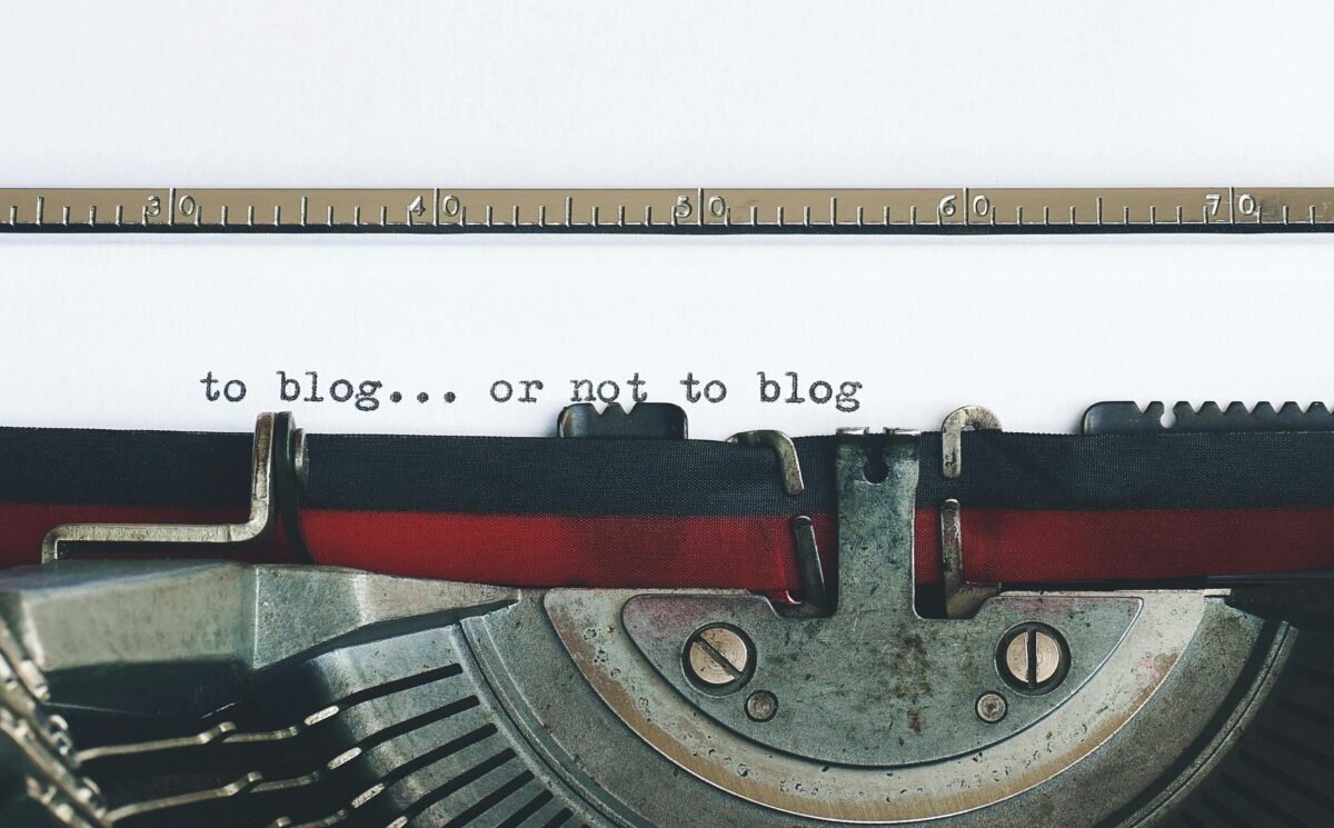 Image of a vintage typewriter with a sheet of paper displaying the text: 'to blog... or not to blog,' prompting contemplation about starting or continuing a blog.