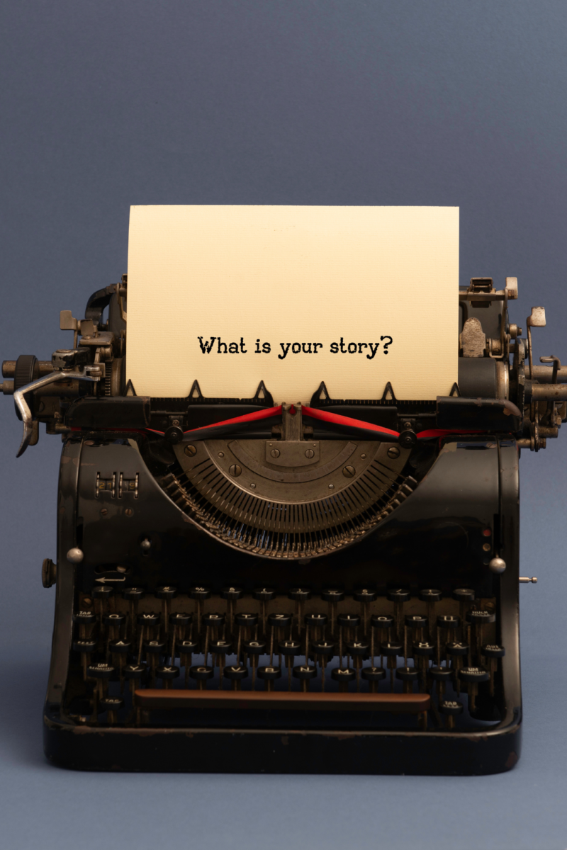 A vintage black typewriter with a sheet of paper that reads "What is your story?" set against a blue background, representing the themes of storytelling, personal narratives, and creative expression.